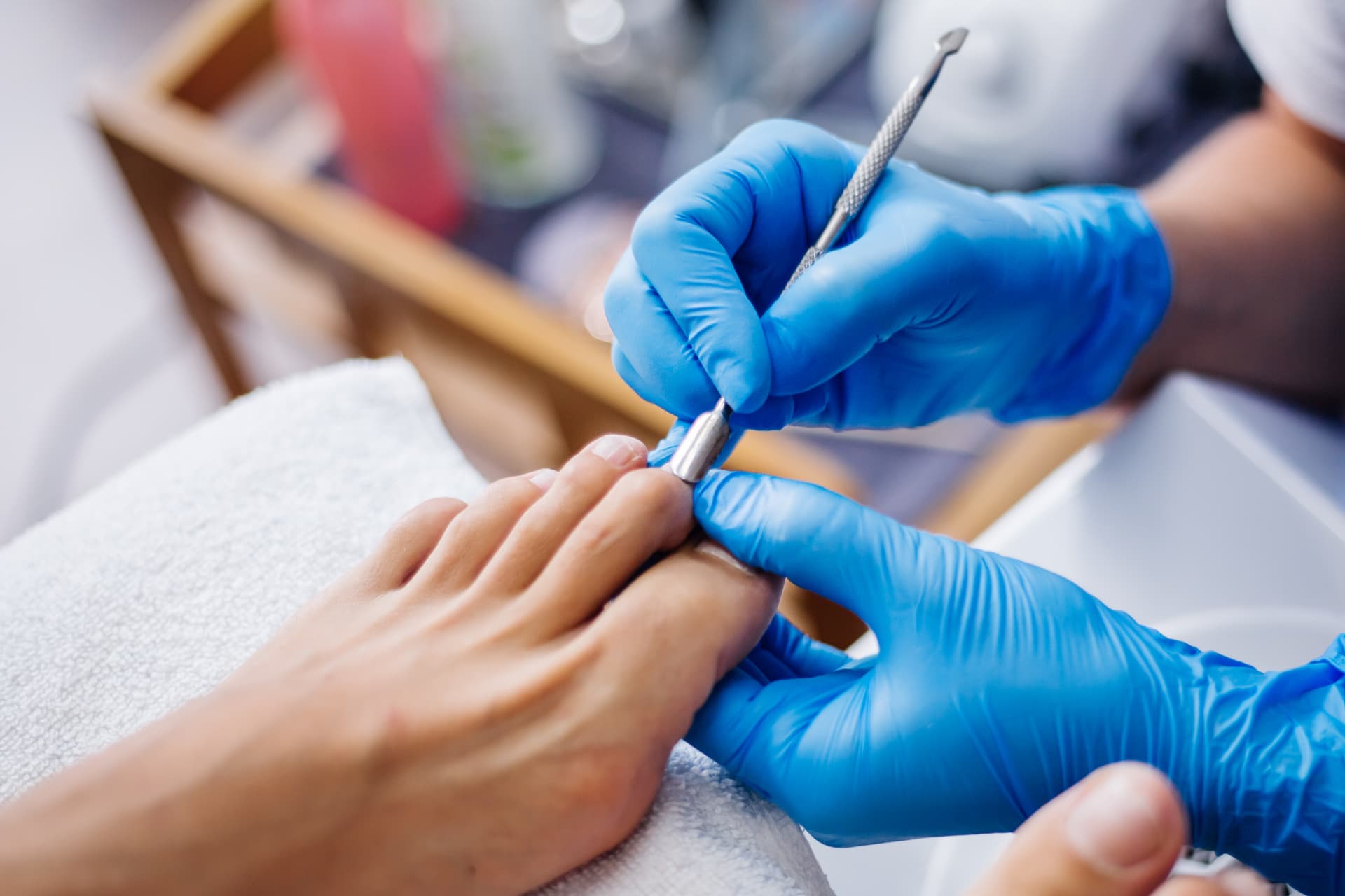 Cuidado rutinario de uñas de los pies con guantes limpios e instrumental desinfectado